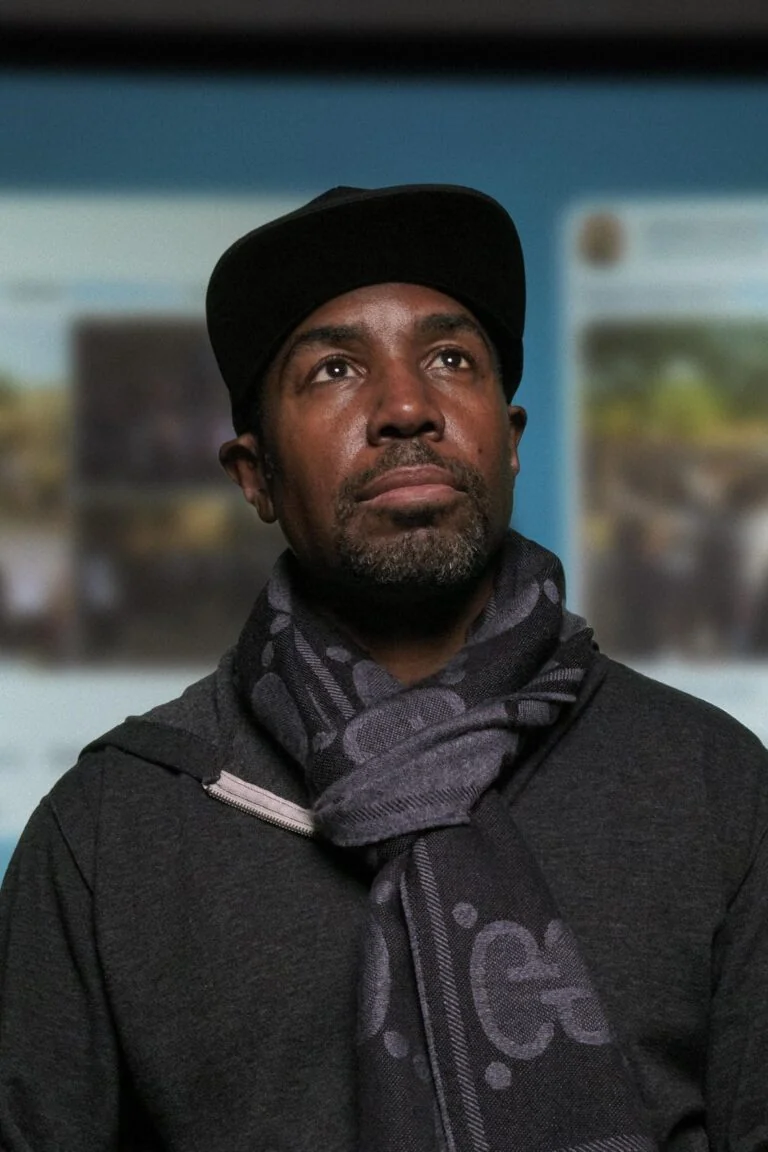 man looking up with a projection of Black Twitter in the background